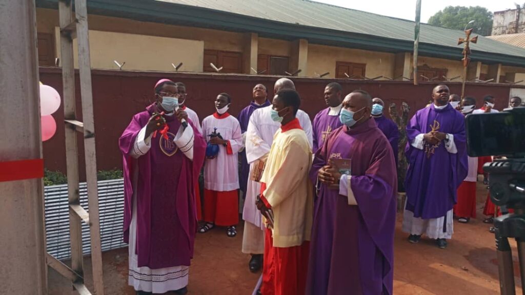 The bishop chats with the school manager at the borehole site.